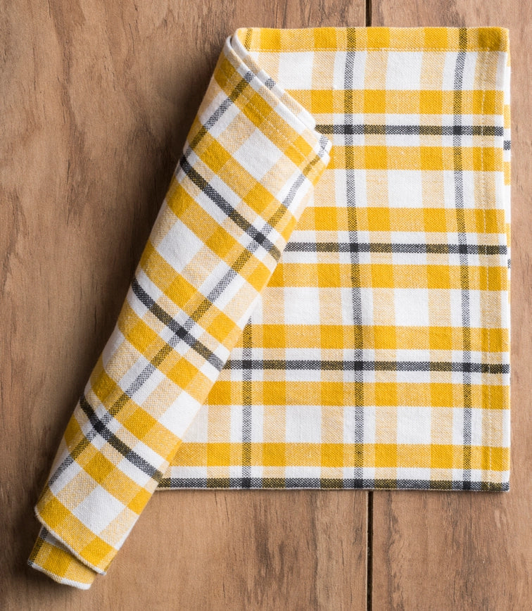 Yellow and white plaid blanket on a wooden surface