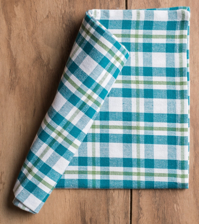 Rolled-up blue and green plaid fabric  napkin on a wooden surface