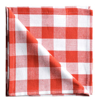 Folded red and white checkered fabric on a white surface