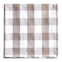Checkered fabric napkin with brown and white pattern on a gray surface