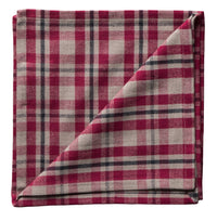Folded red and white plaid napkin on a white background