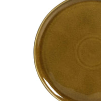 Brown ceramic plate with reactive glaze on a light gray background