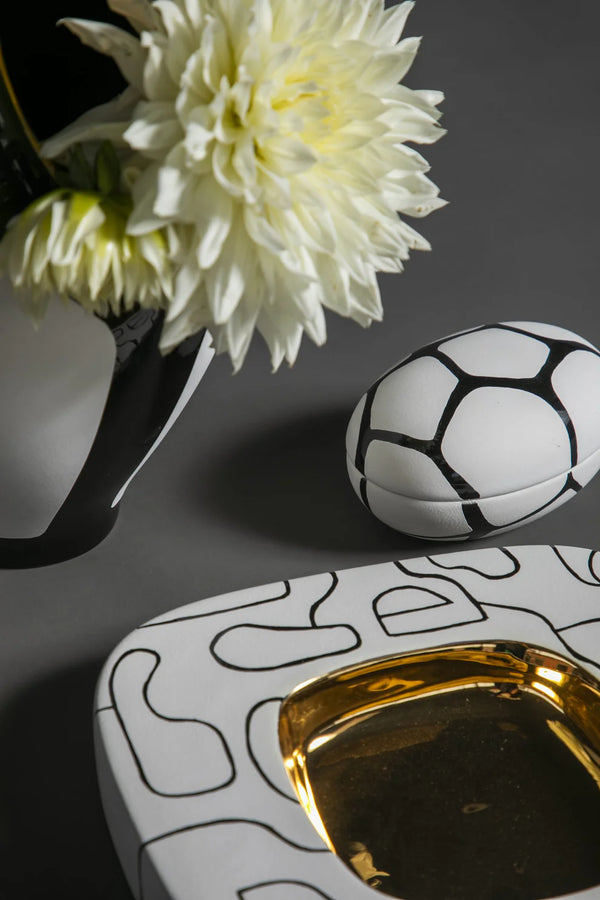 Decorative boxes with geometric patterns and a white flower on a dark background