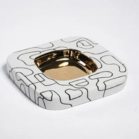 Ceramic ashtray with gold interior on a white background