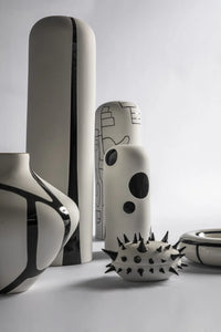 Collection of unique ceramic vases with abstract designs on a light gray background