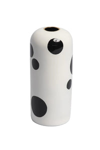 White vase with black polka dots on a white background