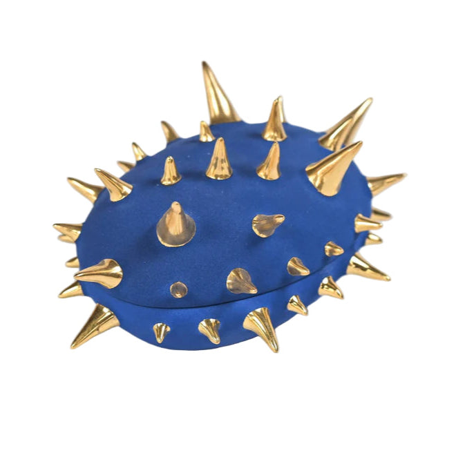Blue object with gold spikes on a white background