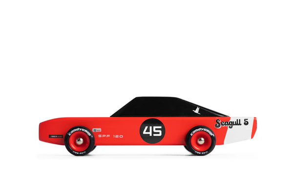 Red toy car with black top and white sides on a white background