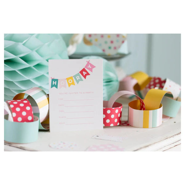 Colorful party decorations with a 'Happy Birthday' card on a white surface.