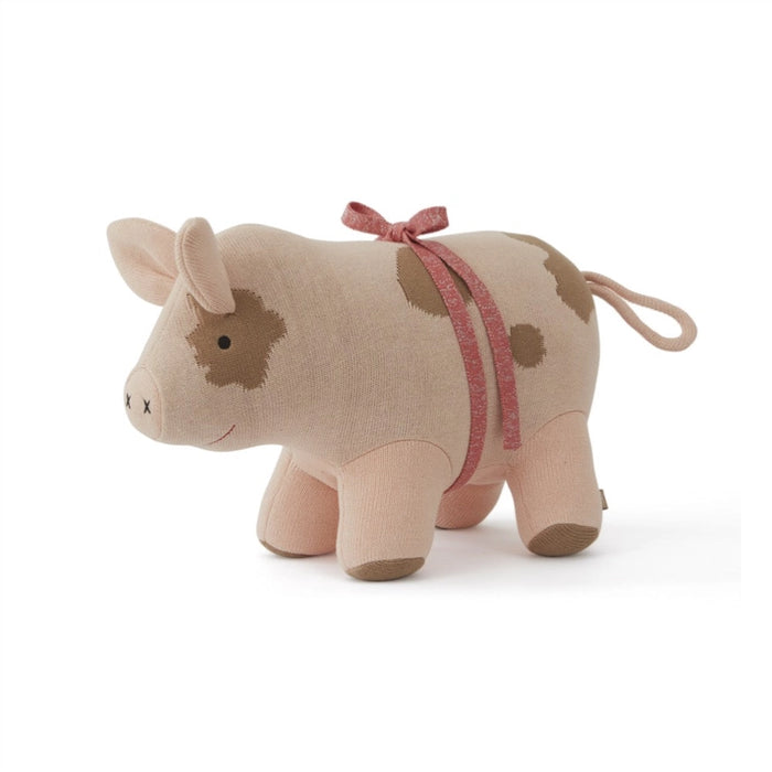 Plush cow toy with a pink ribbon on a white background