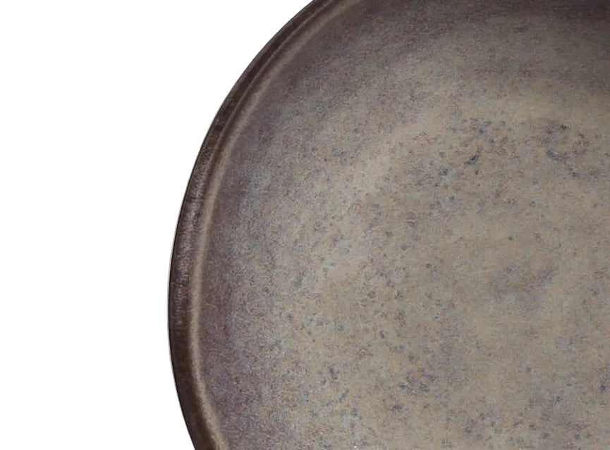 Close-up of a ceramic plate with reactive glaze on a white background