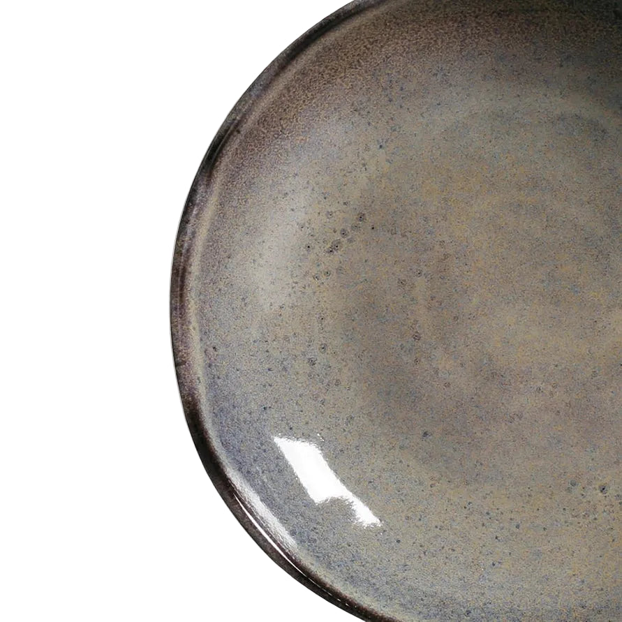 Close-up of a ceramic plate with reactive glaze on a white background