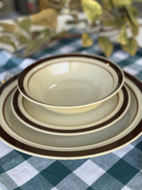Set of ceramic bowls with brown rim on a checkered tablecloth