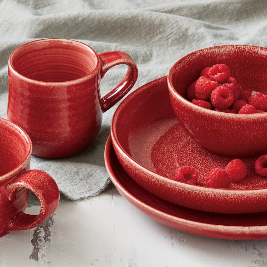 raspberry red tableware on a table with a linen napkin 
