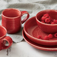raspberry red tableware on a table with a linen napkin 