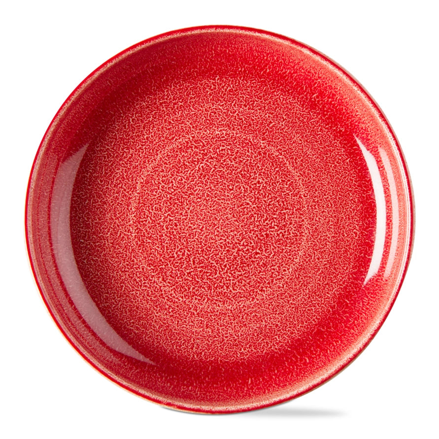 A round ceramic plate with a vibrant red, textured glaze, shown from a top-down perspective on a clean white background.