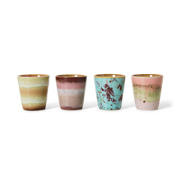 Four ceramic cups with multicolored glaze on a white background