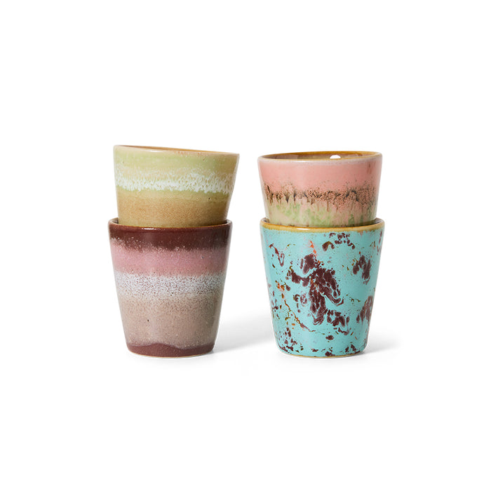 Set of four ceramic cups with multicolored glaze on a white background