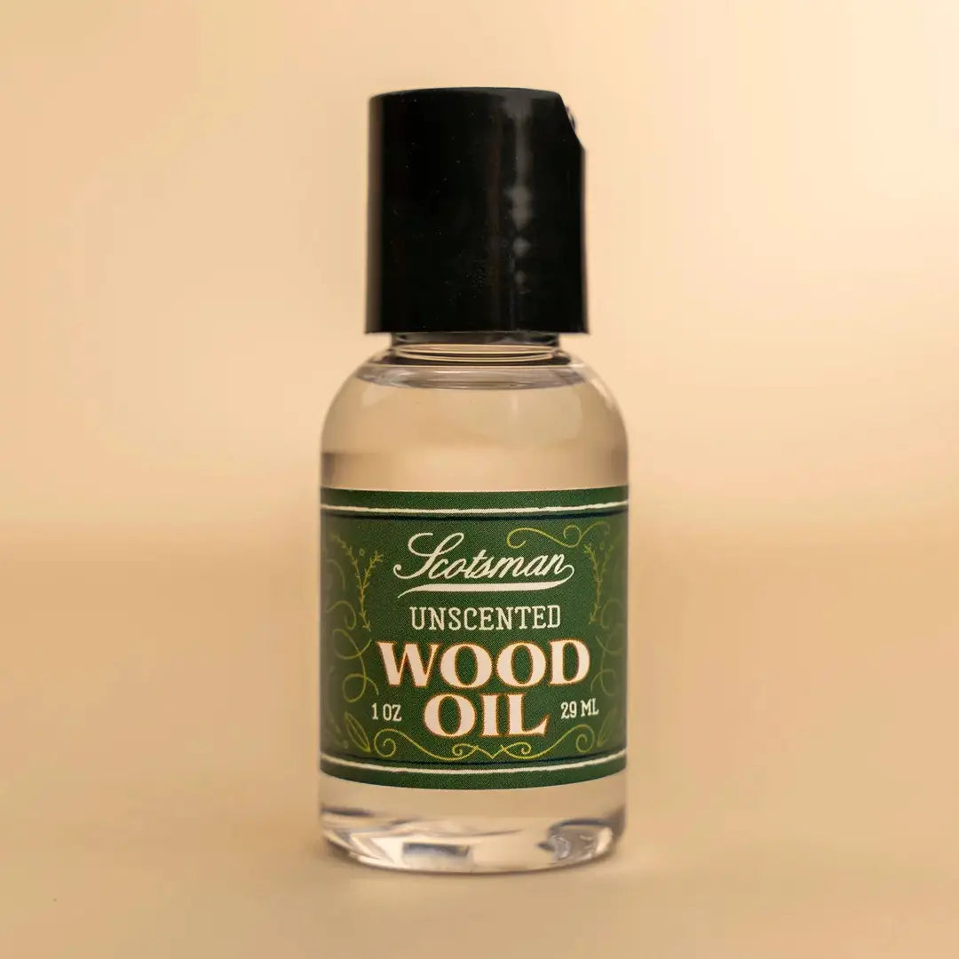 A 29 mL bottle of Scotsman Unscented Wood Oil with a black cap and a green label, set against a solid beige background.