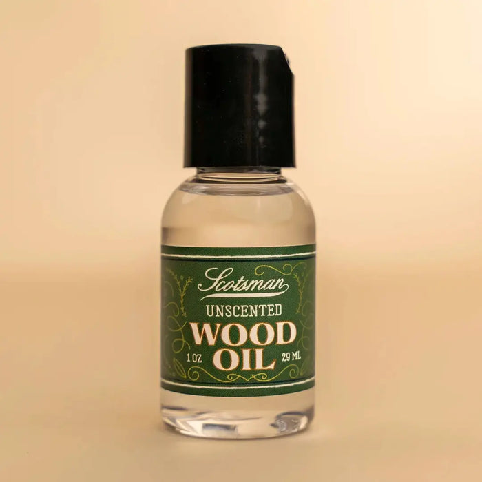 A 29 mL bottle of Scotsman Unscented Wood Oil with a black cap and a green label, set against a solid beige background.