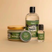 A set of four Lachman Scottish Wood Care products arranged on a warm beige background: a large bottle of wood oil, a small bottle of wood oil, a jar of wood wax with a gold lid, and a tin of wood wax with the lid off.