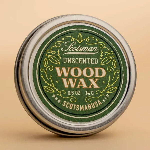 A round metal tin of Scotsman Unscented Wood Wax, featuring a dark green label with gold and white lettering, set against a warm beige background.