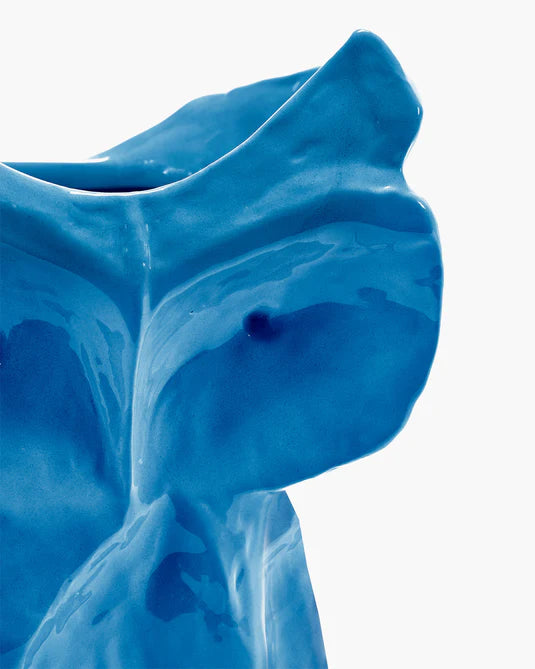 detail of blue ceramic owl vase on white background