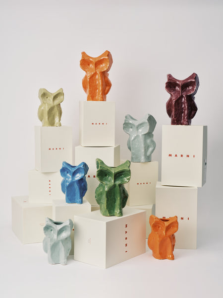 variation of colored ceramic owl vases on white boxes with Serax logo