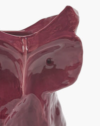detail of maroon ceramic owl vase on white background