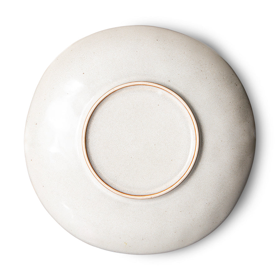 White ceramic plate with a gold rim on a white background