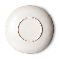 White ceramic plate with a gold rim on a white background