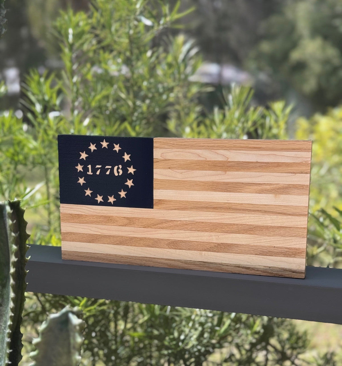Wooden flag with 1776 design on a stand outdoors