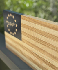 Wooden surface with a black rectangular object featuring star patterns and text, against a blurred green background.