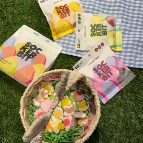 Soc Ker Bit candy packages on a checkered cloth with a basket of candy