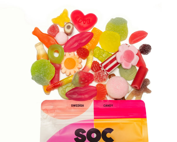 Assorted colorful candies with a pink and orange bag labeled 'Swedish Candy SOC' on a white background.