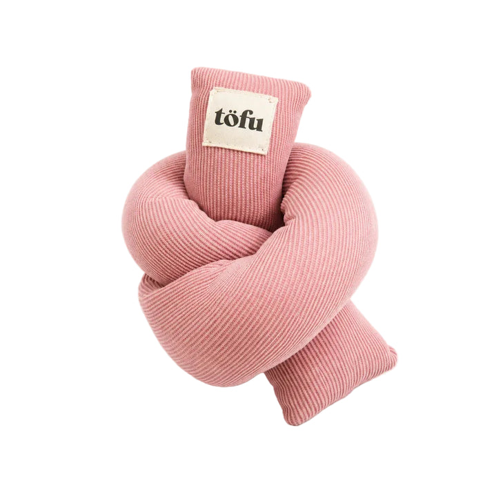 A pink ribbed fabric dog toy shaped like a knot, with a small cream-colored sewn label on the top loop that reads 'töfu'.
