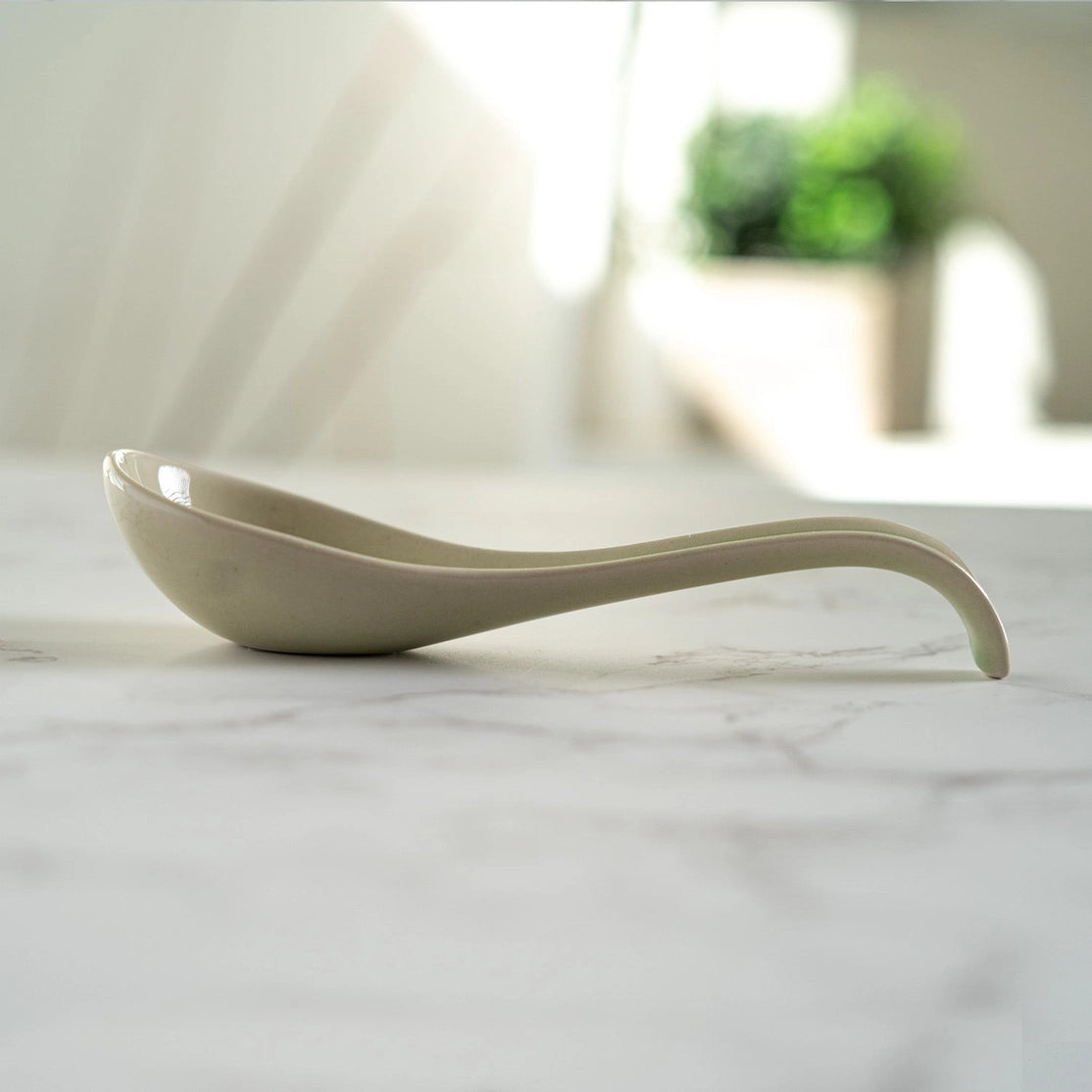 White ceramic spoon on a marble surface with a blurred background