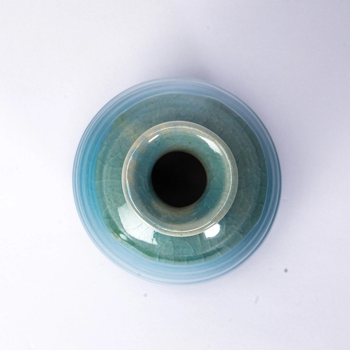 Ceramic eye-shaped object with a blue and black design on a white background