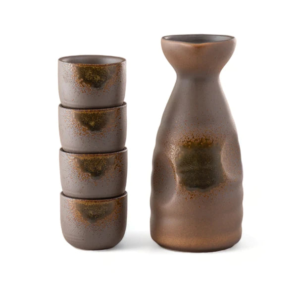 Set of brown ceramic tumblers and a bottle on a white background