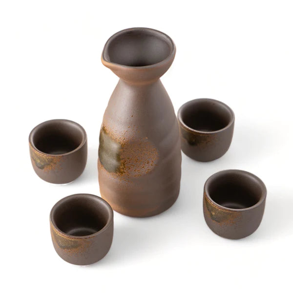 Set of brown ceramic sake bottles and cups on a white background