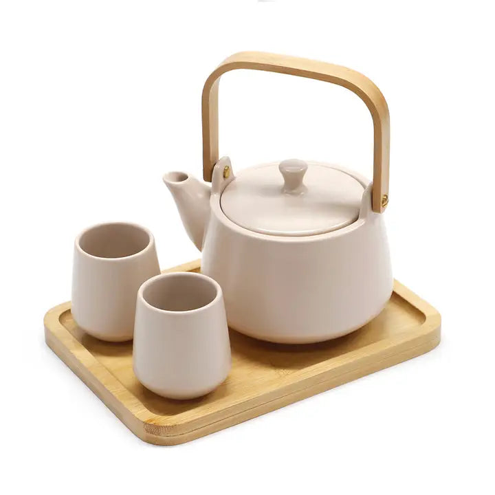 Ceramic teapot with wooden handle and two cups on a wooden tray