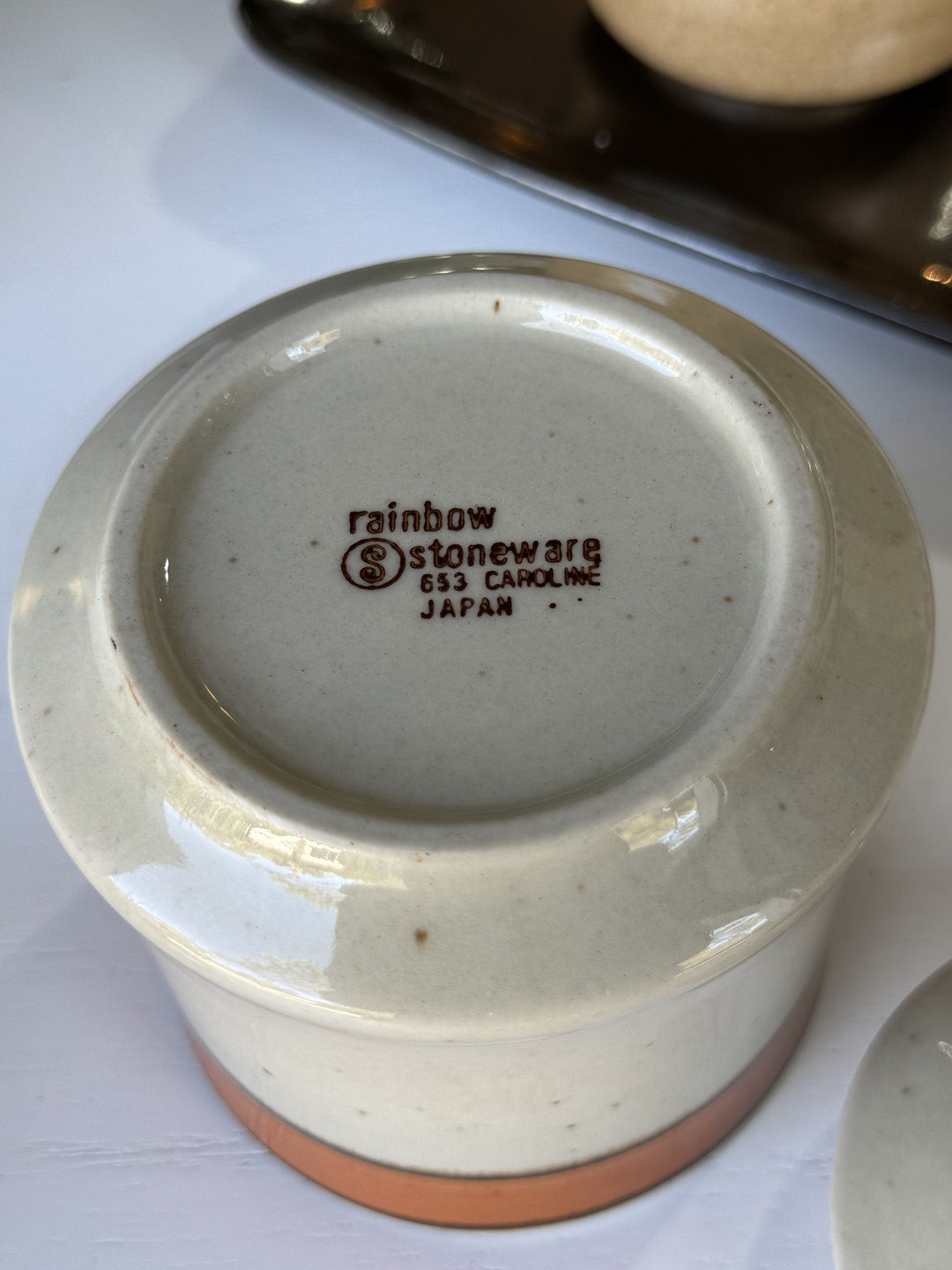 Ceramic product with 'rainbow Stoneware' branding on a white surface