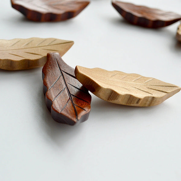 Wooden leaf-shaped coasters on a light surface