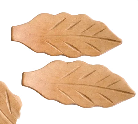 Two leaf-shaped chopstick holders on a white surface
