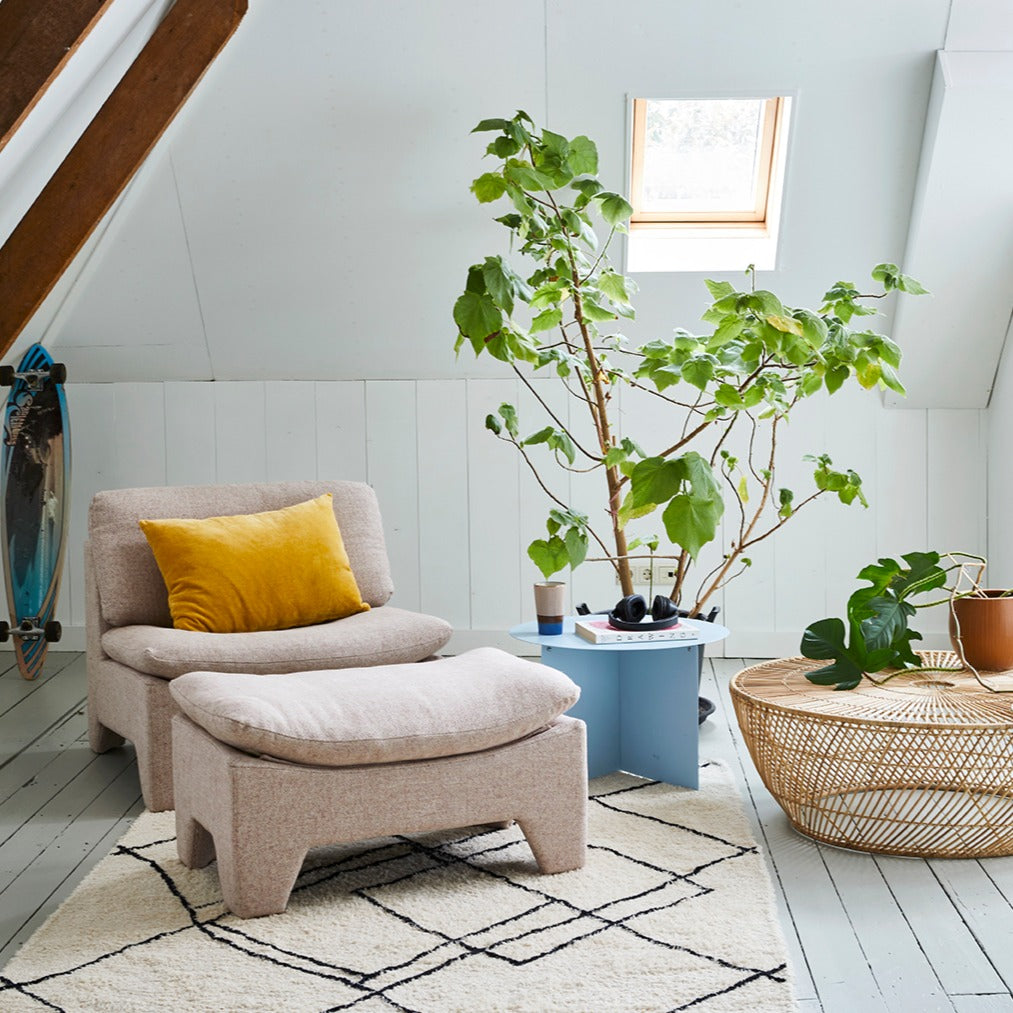 Nordic style living room with a mixture of materials like wool, cotton rattan and wood and soft pastel colors 