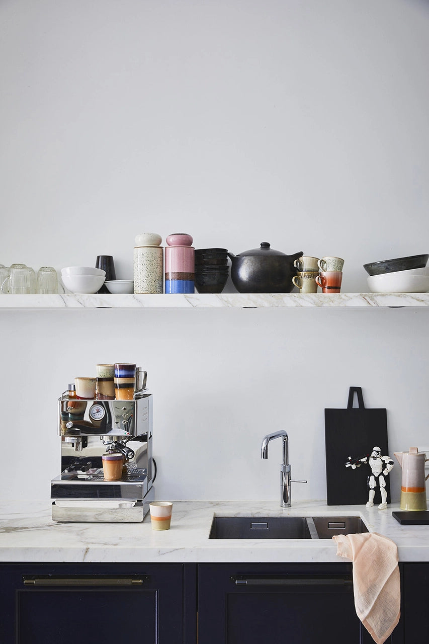 open shelving with ceramics and two storage jars with lid in white and purple