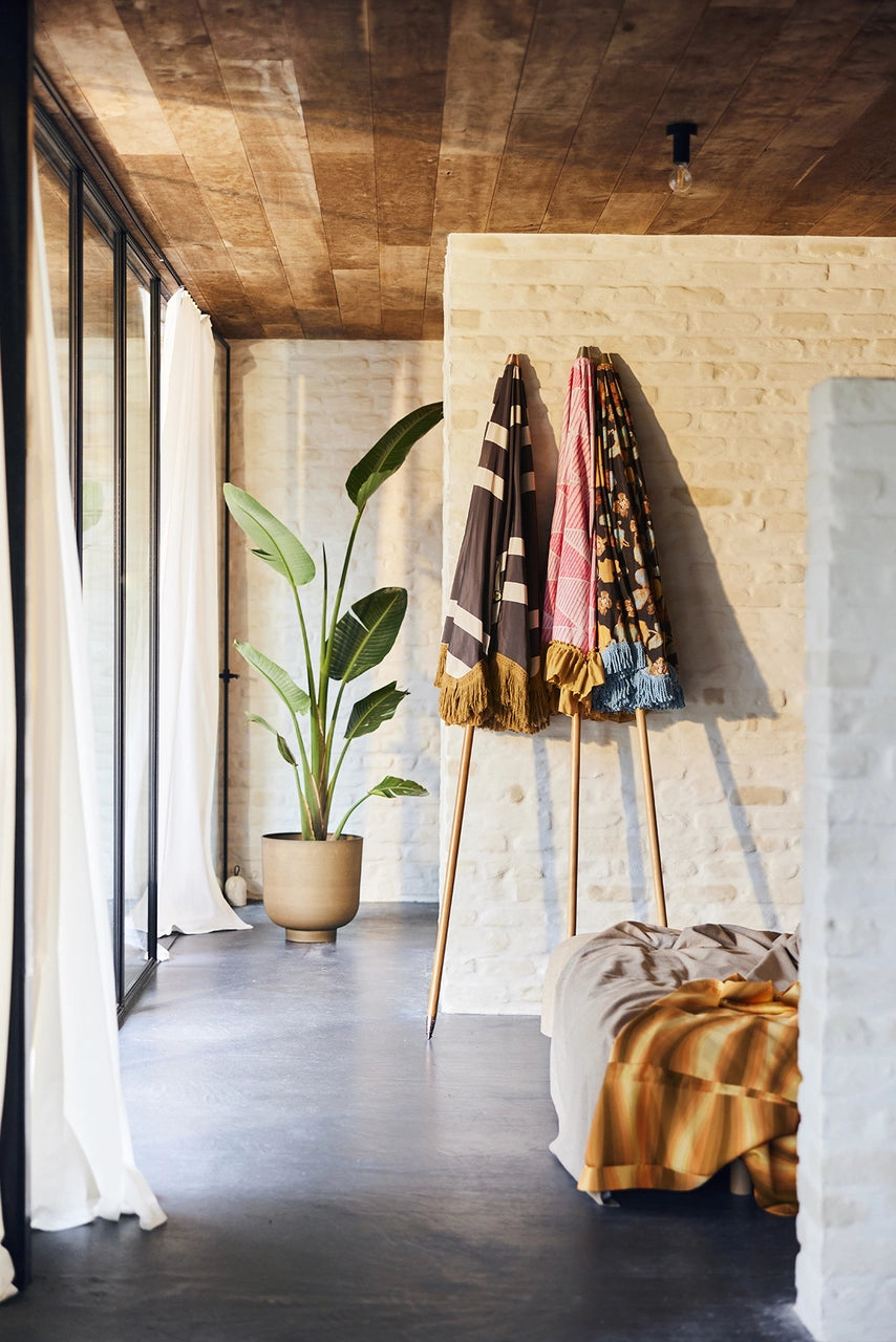 bedroom with sandstone wall with 3 parasols leaning