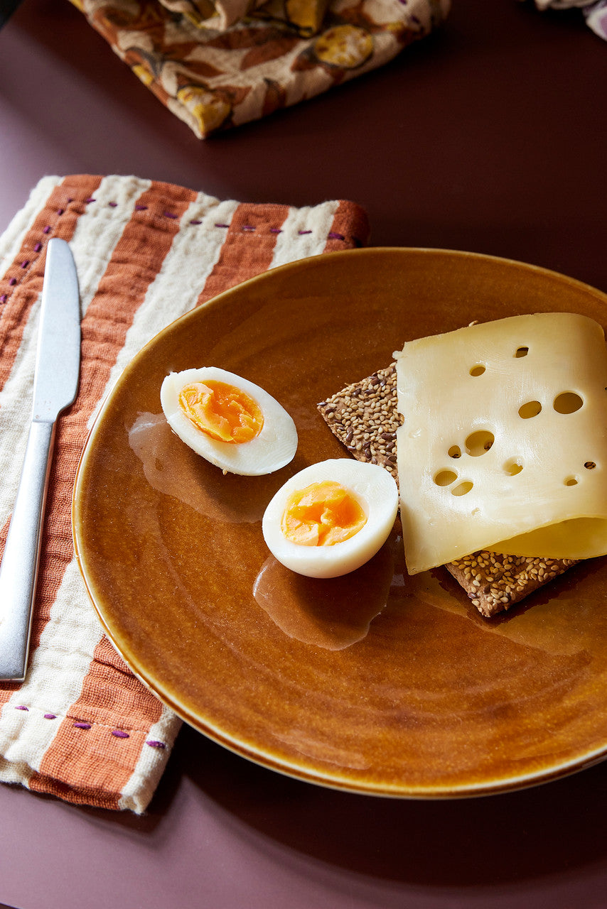 brown plate with a striped napkin
