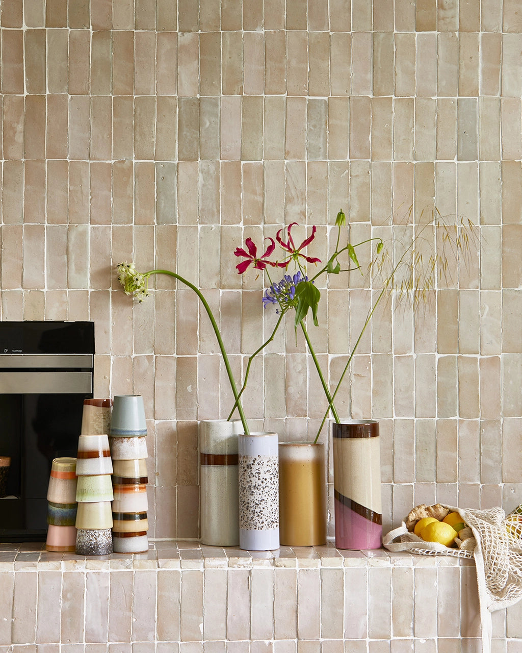 retro style stoneware vases placed in a group on a beige tile wall