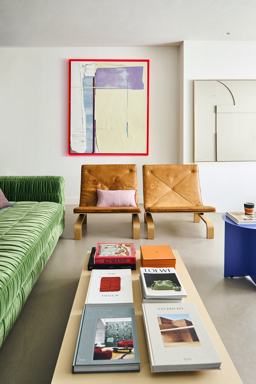 cream white, black, brown orange and lavender colored small stoneware coffee cup in retro style on a blue side table in a living room